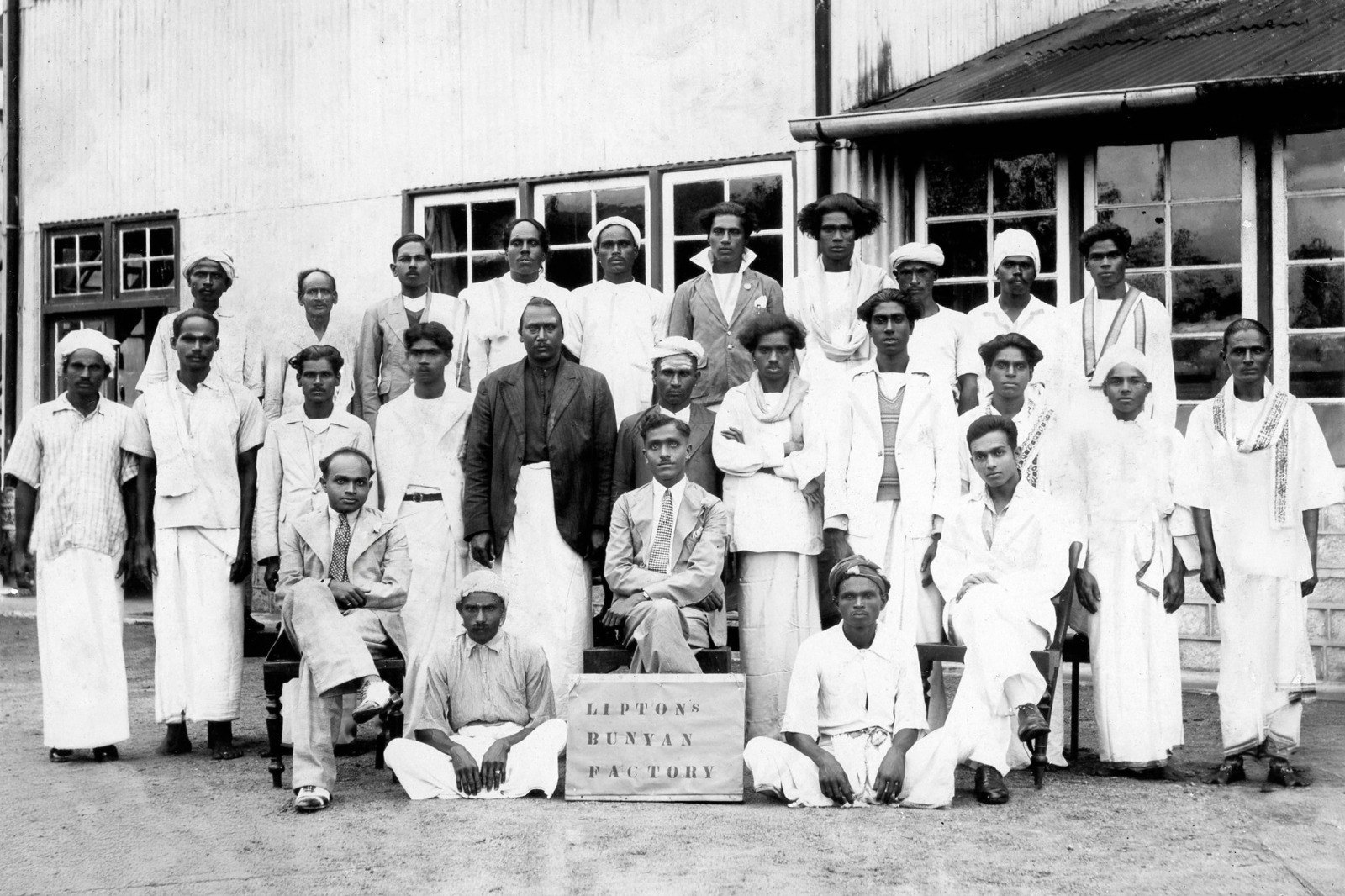 Historical group photograph of staff at a Lipton tea factory in the early 1900s, with the K1 Origins founder’s grandfather seated at the front centre.